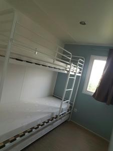 Zimmer mit 2 Etagenbetten und einem Fenster in der Unterkunft Oh! Camping - Les Roquilles Palavas les Flots in Palavas-les-Flots