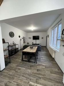 sala de estar con mesa de madera y sofá en Maison avec cours privative, en Nesle