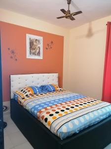 a bed in a room with a ceiling fan at Résidence Togoliving in Toudji +44 photos
