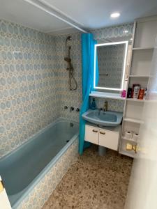 uma casa de banho com uma banheira azul e um lavatório. em VistaSol em Torremolinos