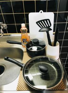 a kitchen sink with a frying pan and utensils at Warm House3 in Sapporo
