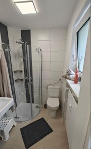 a bathroom with a shower and a toilet and a sink at Ferienwohnung Sorgenfrei - Parkplatz, Balkon & Terrasse in Coburg
