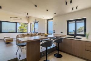 una cucina e un soggiorno con un grande tavolo e sedie di Villa Anasa-Luxury Retreat-Private Pool a Marathónas (Maratona)