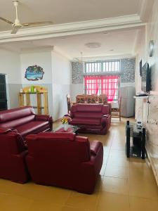 ein Wohnzimmer mit roten Sofas und eine Küche in der Unterkunft Résidence Togoliving 
