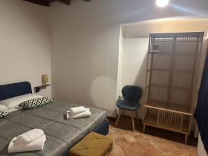 ein Schlafzimmer mit einem Bett und einem blauen Stuhl in der Unterkunft FEEL - Piazza Pontida Balcony Apartment in Bergamo