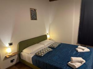 a bedroom with a blue bed with two pillows at FEEL - Piazza Pontida Balcony Apartment in Bergamo