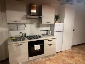 a kitchen with a stove and a sink and a refrigerator at FEEL - Piazza Pontida Balcony Apartment in Bergamo