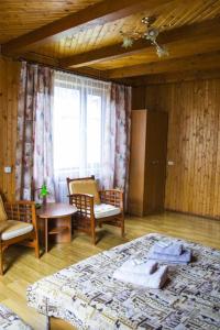 um quarto com uma cama e cadeiras e uma janela em Kryvorizka Palanka em Mykulychyn