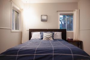 - une chambre avec un lit doté d'une couverture bleue et d'une fenêtre dans l'établissement Chalet plein air, à Saint-Raymond