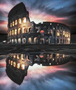 un edificio con su reflejo en el agua por la noche en Il Nido en Roma