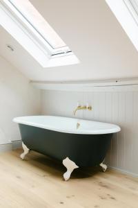 een badkamer met een bad en een dakraam bij Henley Bolt Hole in Henley on Thames