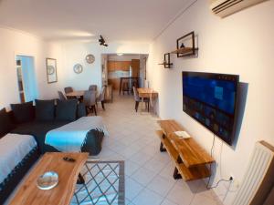 ein Wohnzimmer mit einem Sofa, einem TV und einem Tisch in der Unterkunft Acropolis view Luxury 2-bedroom Condo in Athen