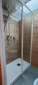 ein Bad mit einer Dusche und Holzwänden in der Unterkunft alloggio in centro con giardino in Sampeire