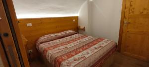 um pequeno quarto com uma cama num pequeno quarto em alloggio in centro con giardino em Sampeire