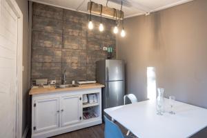a kitchen with a stainless steel refrigerator and a table at Riveras Rentals Bosque , cabañas & cabinas in Algarrobo