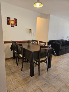 - une table à manger avec des chaises et un canapé dans l'établissement Amplio Depto en Pleno Centro!, à Córdoba