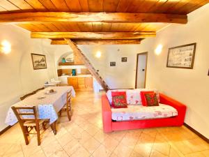 een woonkamer met een rode bank en een tafel bij Trulli Moon in Alberobello