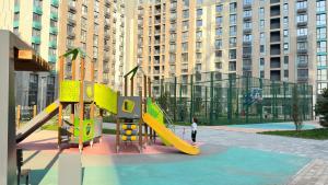 einen Spielplatz mit gelber Rutsche in einer Stadt in der Unterkunft 2х комнатные апартаменты 12-106 in Almaty