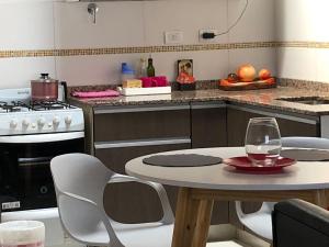 a kitchen with a table and two chairs and a table with a glass at AeroSuites in Las Heras