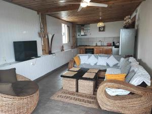 a living room with a couch and chairs and a table at Le Latanier in Petite Île