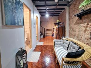 a living room with a couch and a brick wall at MEEMAW'S House Hostel in Bangkok