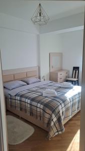 a bedroom with a bed with a blanket and a dresser at Airport-apartament 24&24 Chişinău!!! in Chişinău