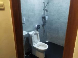 a bathroom with a toilet with the seat up at Asoka Homestay in Senggigi