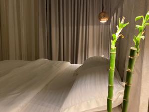شقة مودرن مقابلة البوليفارد في الرياض: غرفة نوم بسرير ابيض ونبات