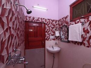 een badkamer met een wastafel en een rode deur bij SPOT ON Hotel Imperial Crown in Sūbedārganj