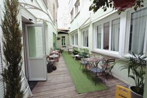 an outdoor patio with tables and chairs and a green rug at Le Saint Louis in Amiens