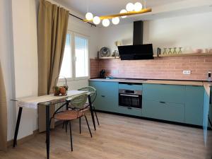 a kitchen with blue cabinets and a table and a tableablish at Mirador de Lindaraja (vistas a la Alhambra) in Granada +10 photos