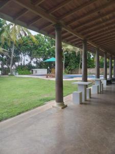 a pavilion with picnic tables and a green park at Olivia Bungalow in Wattala