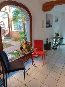 uma sala de estar com uma mesa e uma cadeira vermelha em Amnis em Aquileia
