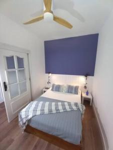 1 dormitorio con 1 cama y ventilador de techo en Una ventana al Mar en Málaga, en Málaga