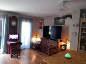 un soggiorno con TV e scrivania con computer di Private Room romantic area a Sitges