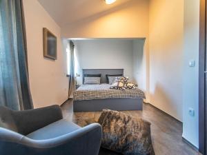 een slaapkamer met een bed, een bank en een stoel bij Luxury and stylish villa with private pool and terrace in Poreč