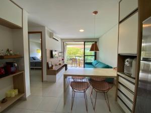 a kitchen and living room with a table and chairs at Paraíso na terra - Carneiros Beach Resort in Tamandaré +26 photos