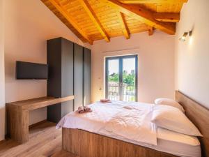 a bedroom with a bed with a tv and a window at Large luxury villa with swimming pool and outdoor kitchen in Svetvinčenat