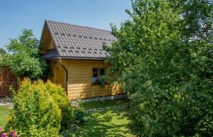 une petite maison en bois avec un arbre dans la cour dans l'établissement Domek góralski u Felusia, à Szczawnica