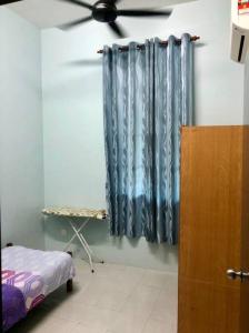 Cette chambre dispose d'un ventilateur de plafond et d'un rideau. dans l'établissement Zara Dija Homestay Klia/Klia2, à Sepang