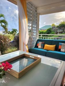 - un salon avec un canapé bleu et une table basse en verre dans l'établissement Anse des rochers - Ti Kaz MiLouMa, à Saint-François