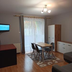 a kitchen and dining room with a table and chairs at Apartament Dunikowskiego 57m2 in Lublin