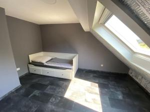 a bedroom with a bed in the corner with a window at Ferien-Villa direkt am Rhein Sauna/Whirlpool in Götterswickerhamm