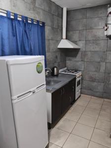 a kitchen with a white refrigerator and a stove at Güemes 4 in General Roca