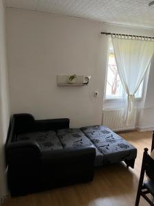 um quarto com uma cama preta e uma janela em Jelka em Sremski Karlovci