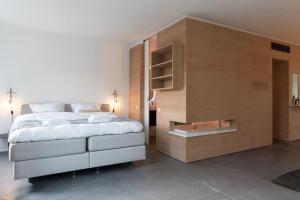 een slaapkamer met een groot bed en een houten muur bij City centre Loft on the historic Canal in Utrecht