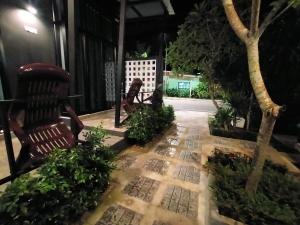 un patio con 2 sillas y algunas plantas en NemoCottage, en Ban Khlong Haeng