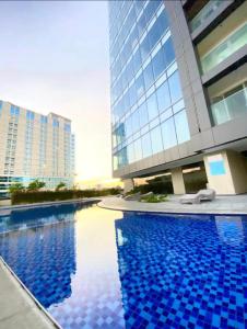 a swimming pool in front of a tall building at Aeon Towers Condotel in Davao City