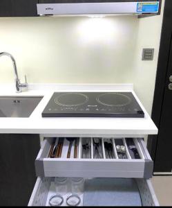 a kitchen with a stove top in a refrigerator at Aeon Towers Condotel in Davao City
