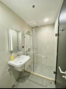 a bathroom with a shower and a sink and a glass shower stall at Aeon Towers Condotel in Davao City